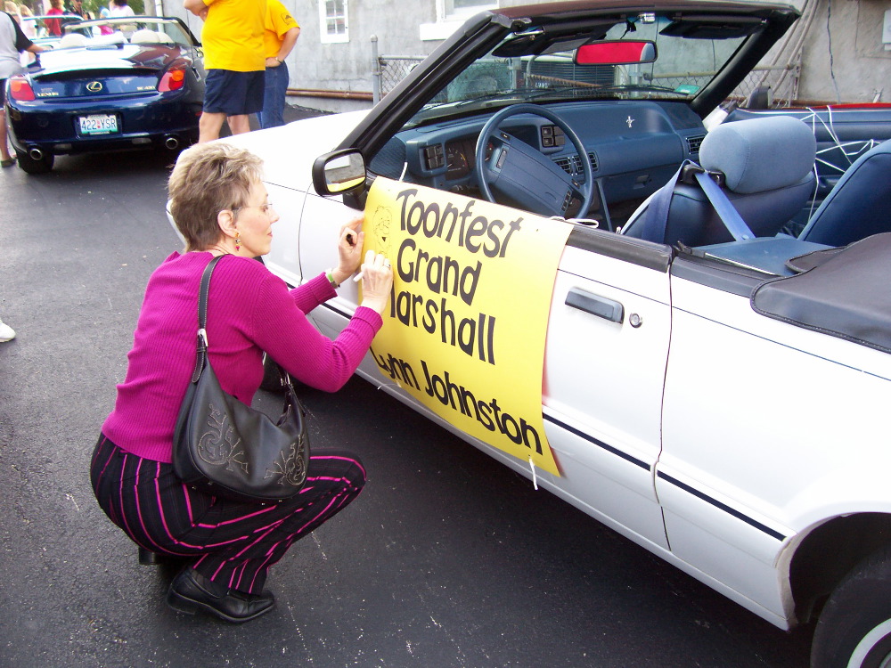 Lynn Johnston doodling on her sign