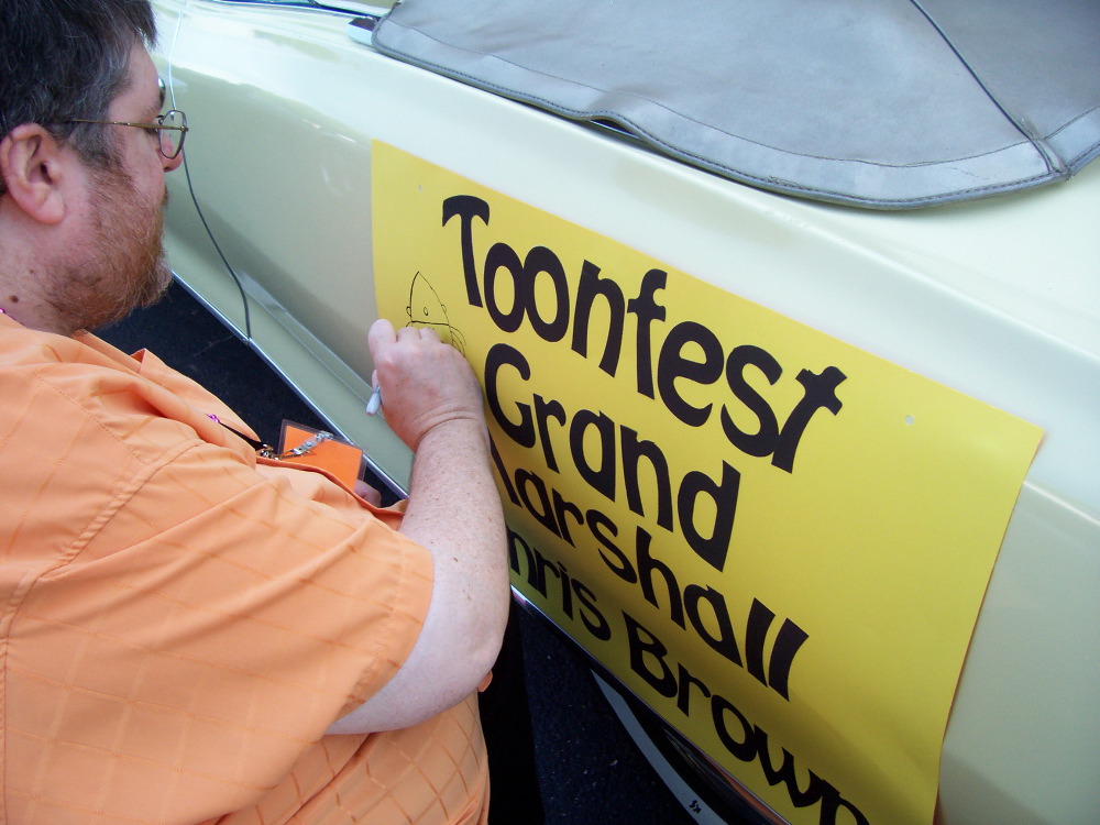 Chris Browne doodling on his sign